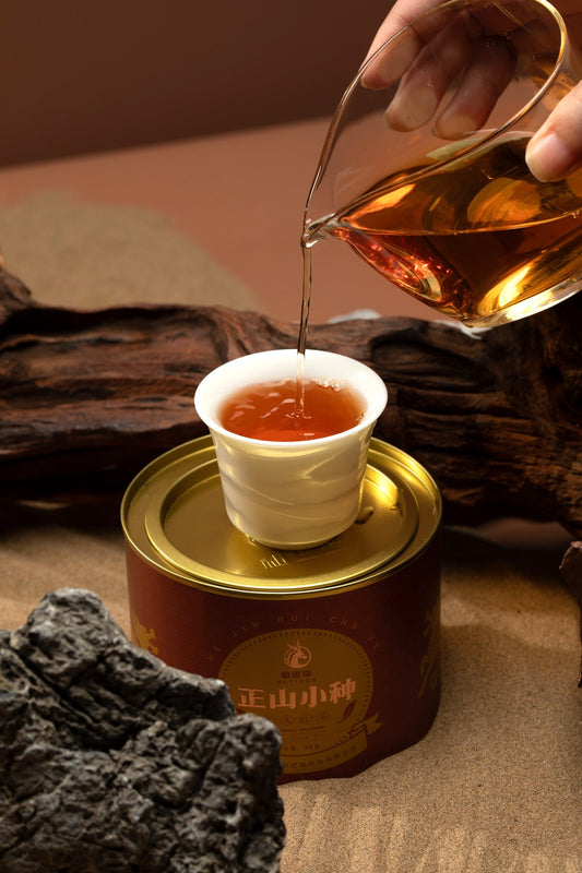 Pouring Lapsang Souchong over the tin — amber liquor